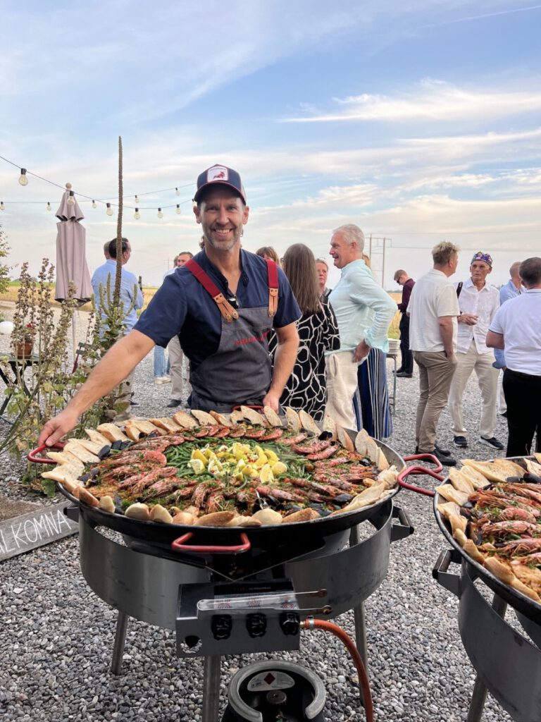 Fredrik Nilsson lagar paella live på en fest i kvällsljus