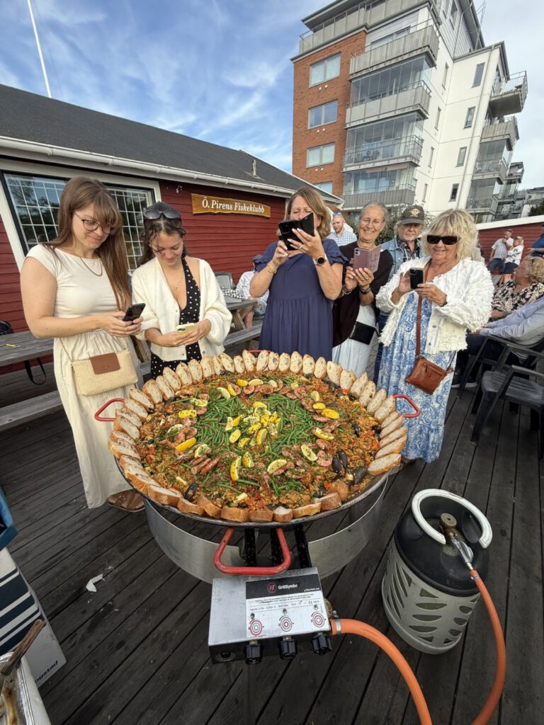 Gäster samlade runt paellapannan vid hamnen